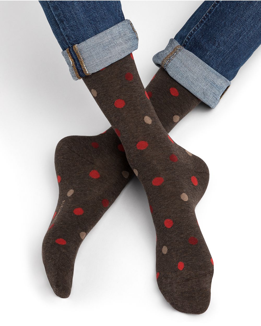 Calzini scuri a pois rossi e beige indossati con jeans